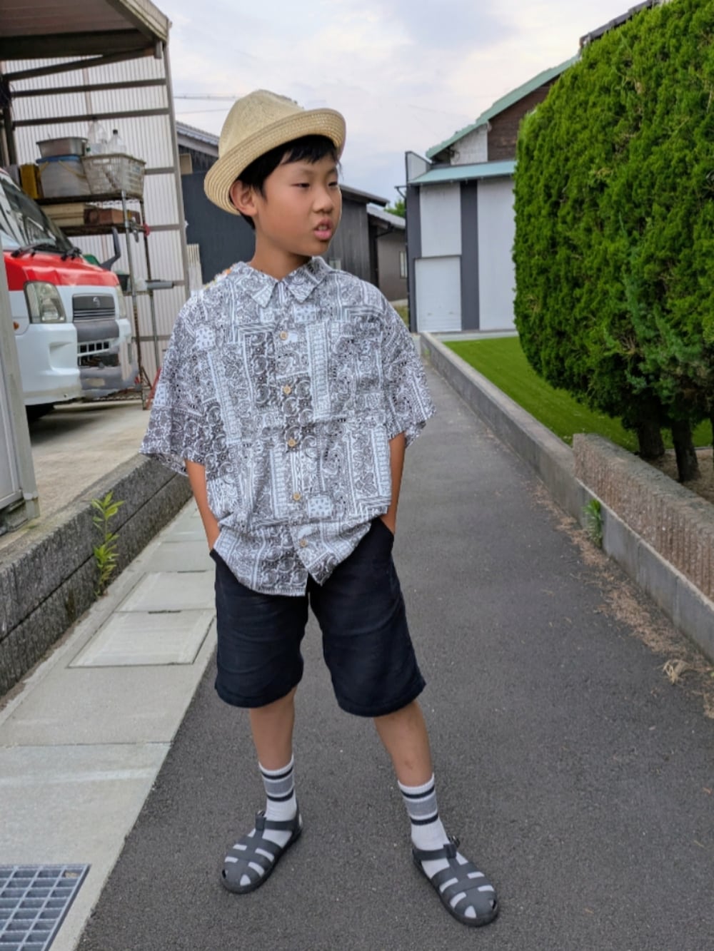 ホワイト系のシャツ/ブラウス、ブラック系のその他パンツ、ブラック系のサンダルを着用したキッズの夏コーディネートの2枚目の写真