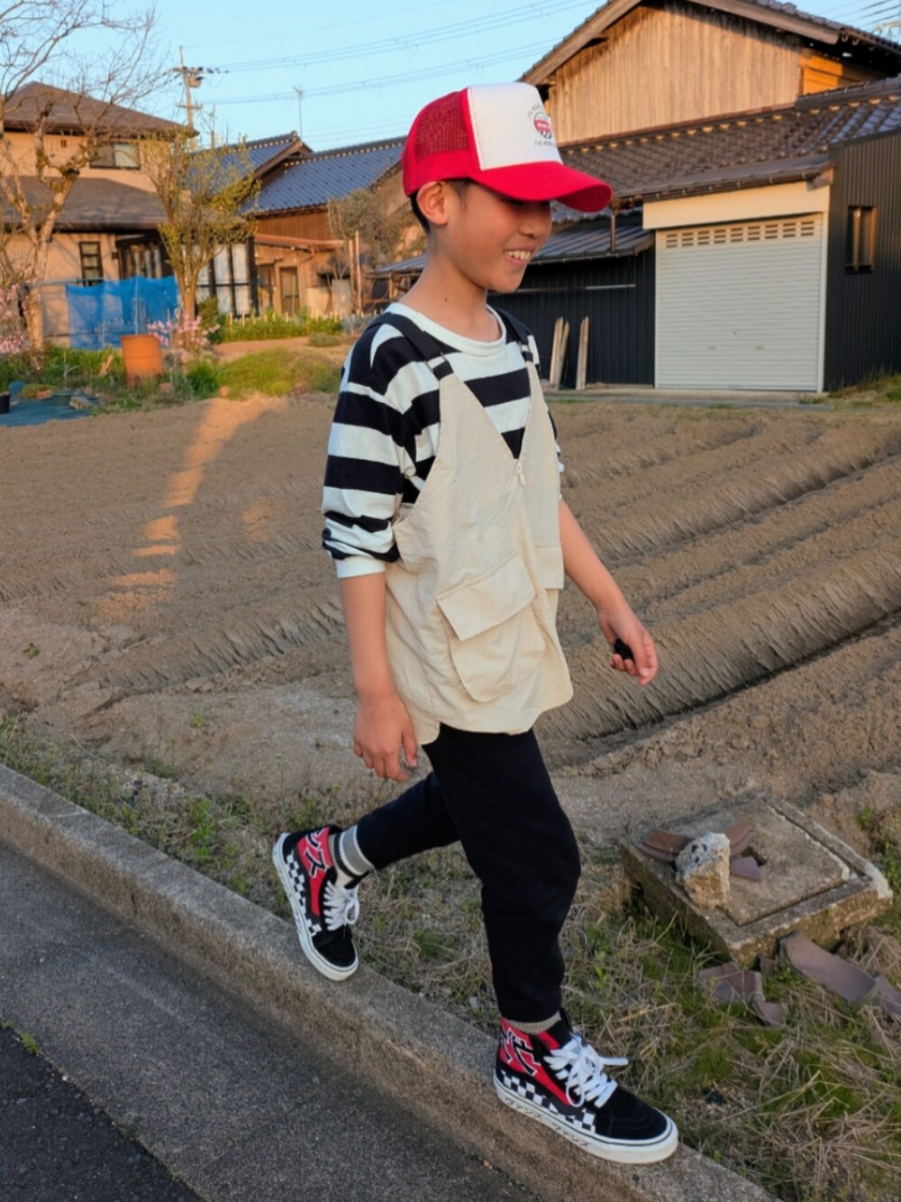 ブラック系のスウェットパンツ、その他のTシャツ/カットソー、ベージュ系のベストを着用したキッズの春コーディネートの2枚目の写真