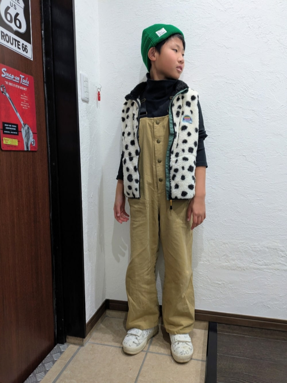 ベージュ系のサロペット/オーバーオール、ホワイト系のベスト、ブラック系のTシャツ/カットソーを着用したキッズの秋コーディネートの3枚目の写真