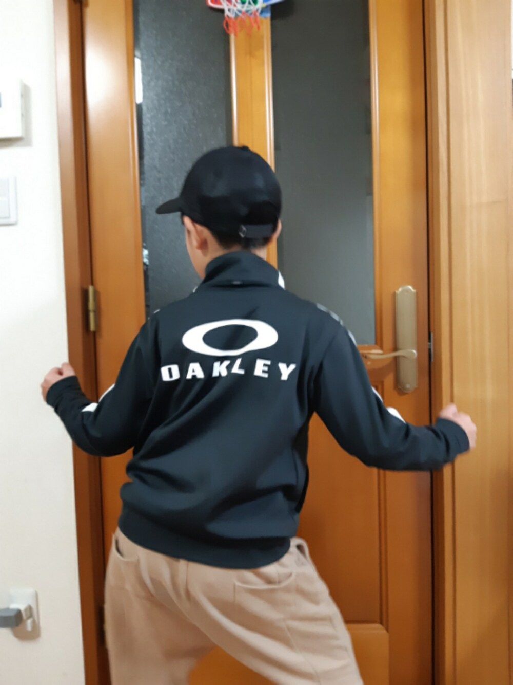 ベージュ系のパンツ、ブラック系のトップス、ブラック系のキャップを着用したキッズの春コーディネートの3枚目の写真