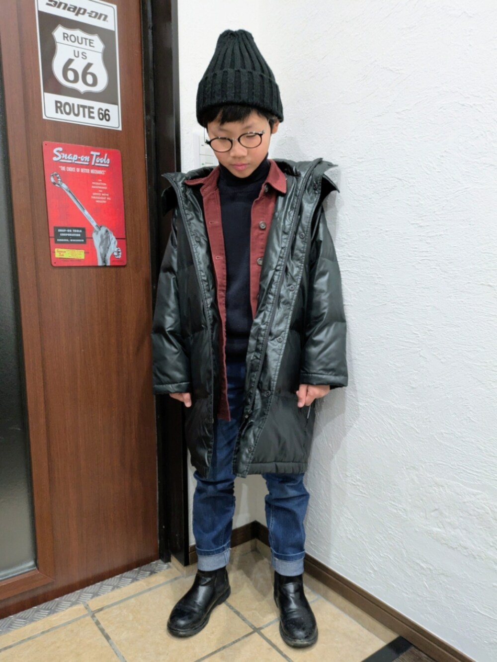 ブルー系のデニムパンツ、ブラック系のニット/セーター、レッド系のシャツ/ブラウスを着用したキッズの冬コーディネートの3枚目の写真