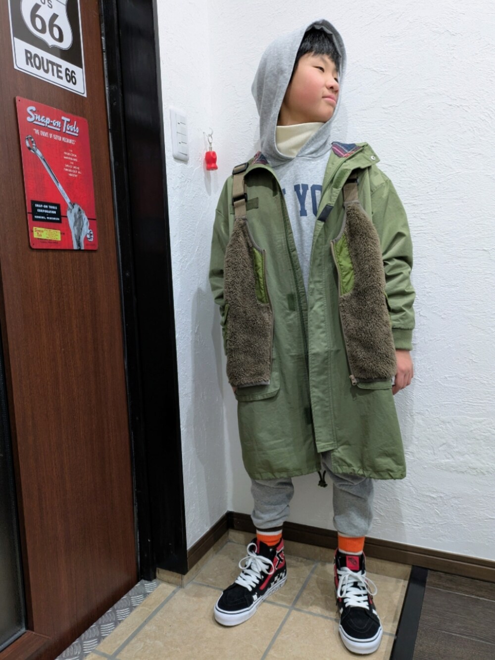 グリーン系のモッズコート、ブラウン系のベスト、その他のパーカーを着用したキッズの冬コーディネートの3枚目の写真