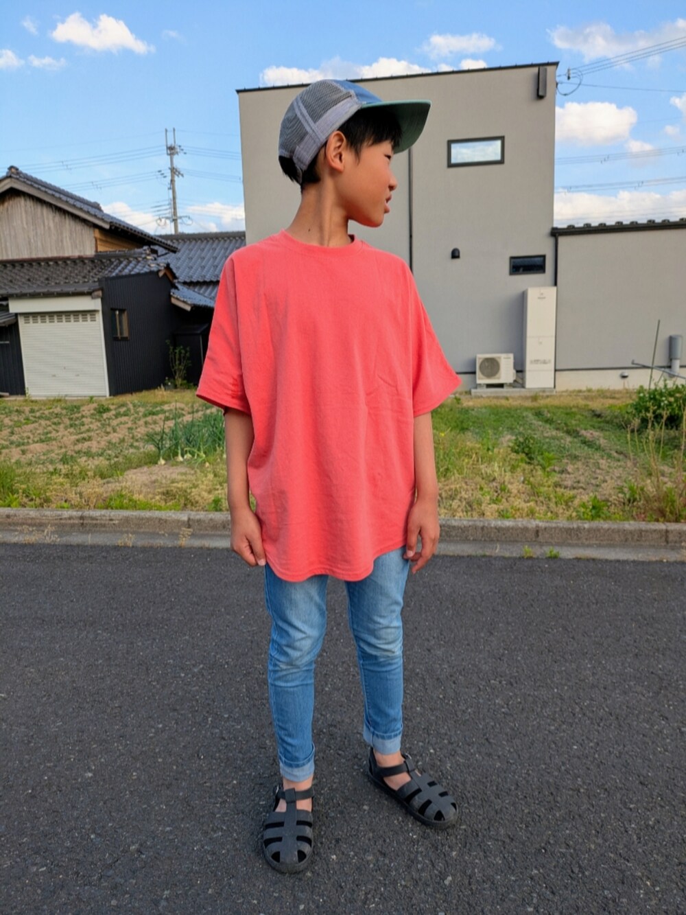 オレンジ系のTシャツ/カットソー、ブルー系のデニムパンツ、ブラック系のサンダルを着用したキッズの夏コーディネートの2枚目の写真