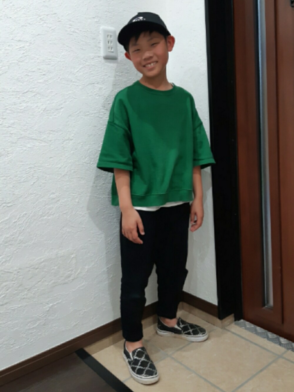 グリーン系のTシャツ/カットソー、ブラック系のチノパンツ、ブラック系のスニーカーを着用したキッズの春コーディネートの2枚目の写真