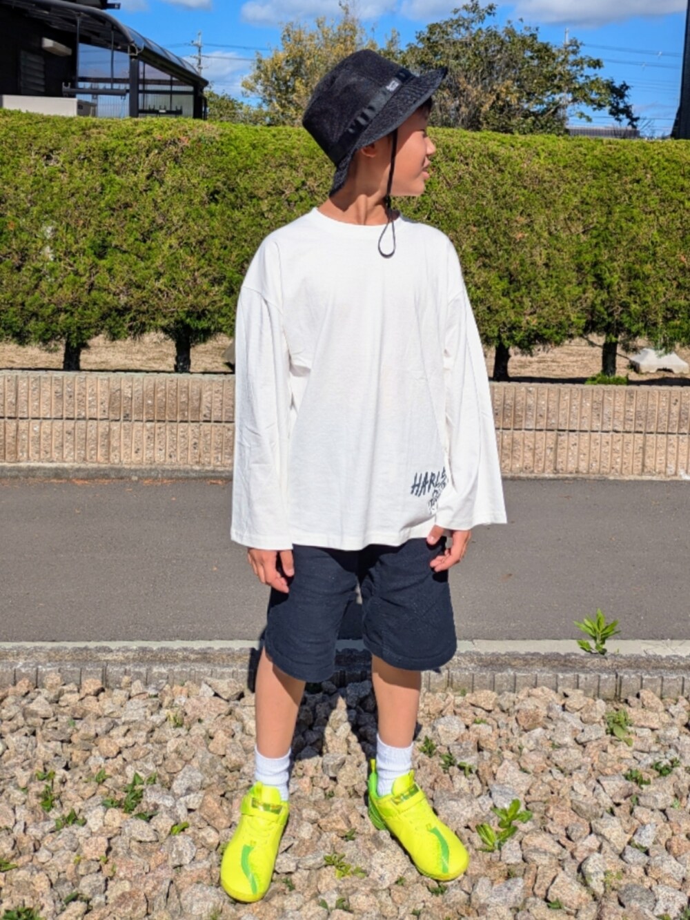 ホワイト系のTシャツ/カットソー、ブラック系のその他パンツ、イエロー系のスニーカーを着用したキッズの秋コーディネートの2枚目の写真