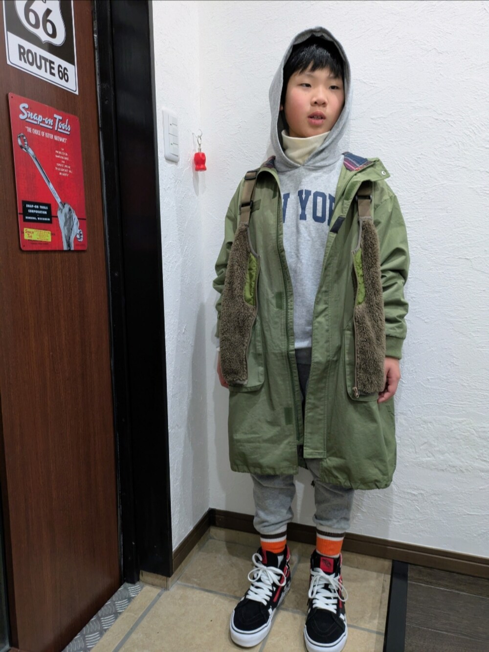 グリーン系のモッズコート、ブラウン系のベスト、その他のパーカーを着用したキッズの冬コーディネートの2枚目の写真