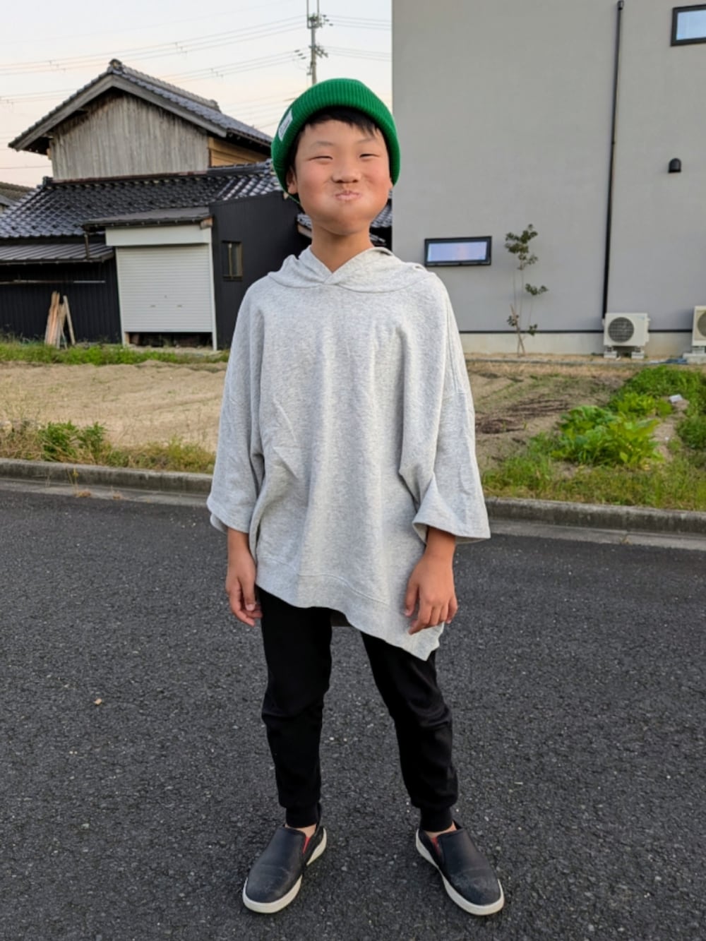 グレー系のパーカー、ブラック系のスリッポン、ブラック系のレギンス/スパッツを着用したキッズの秋コーディネートの3枚目の写真