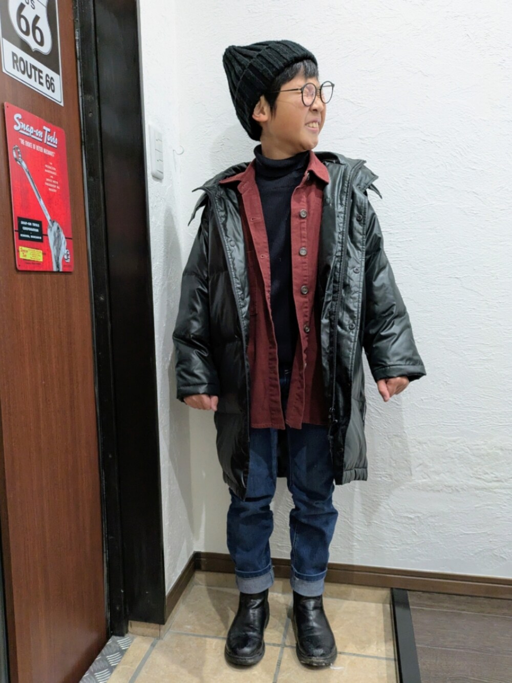 ブルー系のデニムパンツ、ブラック系のニット/セーター、レッド系のシャツ/ブラウスを着用したキッズの冬コーディネートの5枚目の写真