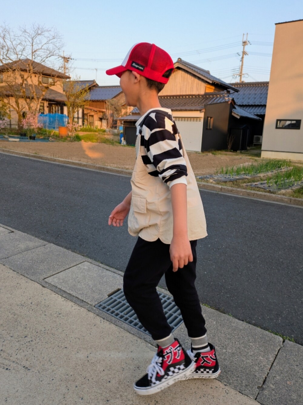 ブラック系のスウェットパンツ、その他のTシャツ/カットソー、ベージュ系のベストを着用したキッズの春コーディネートの3枚目の写真