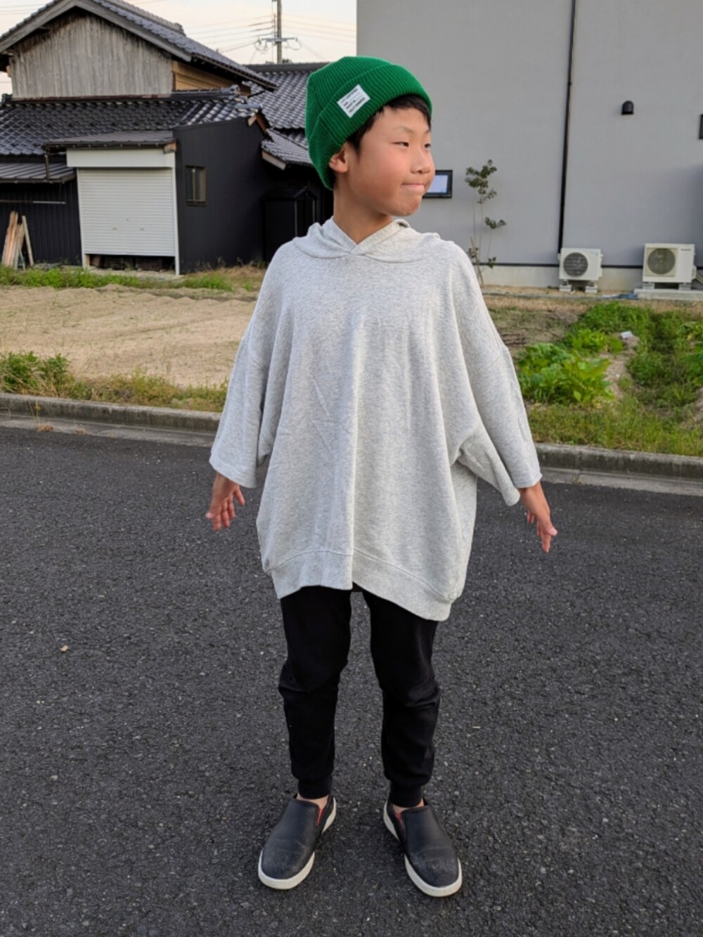 グレー系のパーカー、ブラック系のスリッポン、ブラック系のレギンス/スパッツを着用したキッズの秋コーディネートの2枚目の写真