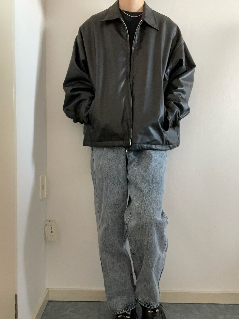 ブラック系のブルゾン、ブルー系のデニムパンツ、ブラック系のニット/セーターを着用したメンズの春コーディネートの2枚目の写真