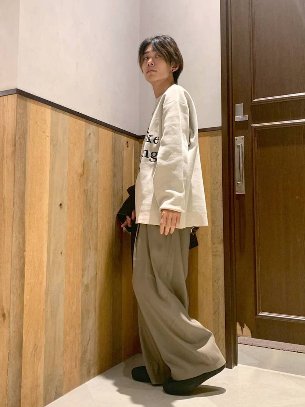 ホワイト系のニット/セーター、ブラウン系のブルゾン、ベージュ系のスラックスを着用したメンズの秋コーディネートの5枚目の写真