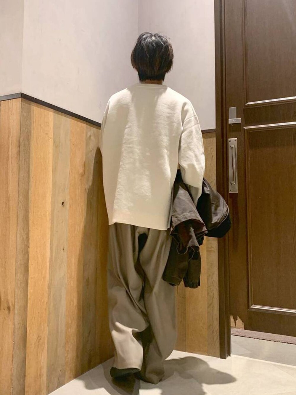 ホワイト系のニット/セーター、ブラウン系のブルゾン、ベージュ系のスラックスを着用したメンズの秋コーディネートの6枚目の写真