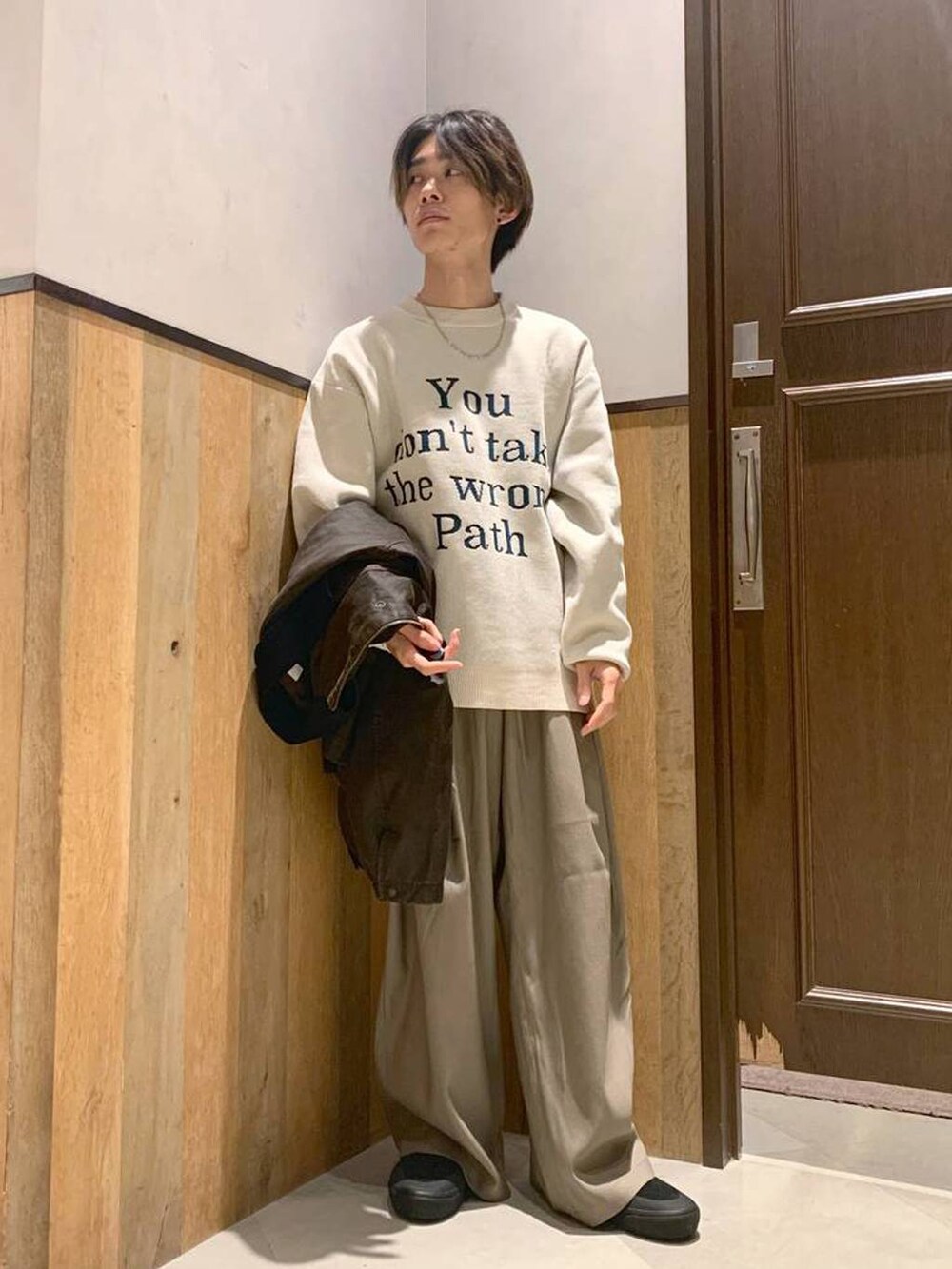 ホワイト系のニット/セーター、ブラウン系のブルゾン、ベージュ系のスラックスを着用したメンズの秋コーディネートの4枚目の写真