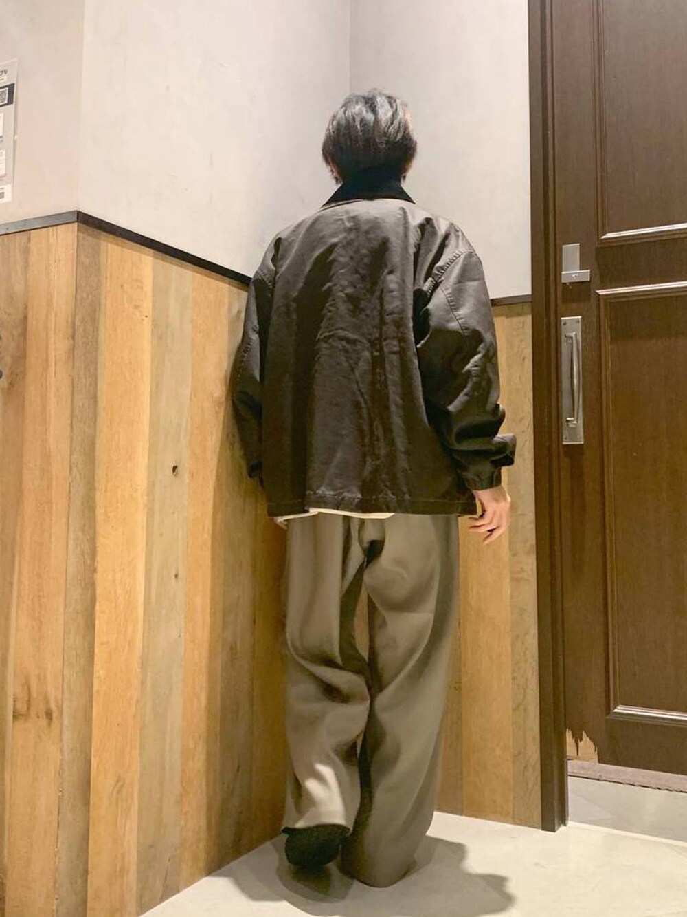 ホワイト系のニット/セーター、ブラウン系のブルゾン、ベージュ系のスラックスを着用したメンズの秋コーディネートの3枚目の写真