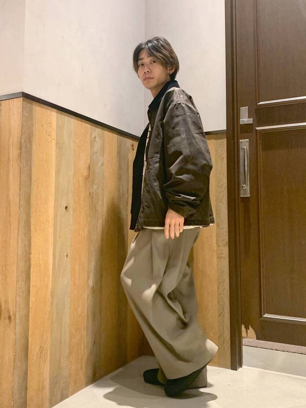 ホワイト系のニット/セーター、ブラウン系のブルゾン、ベージュ系のスラックスを着用したメンズの秋コーディネートの2枚目の写真