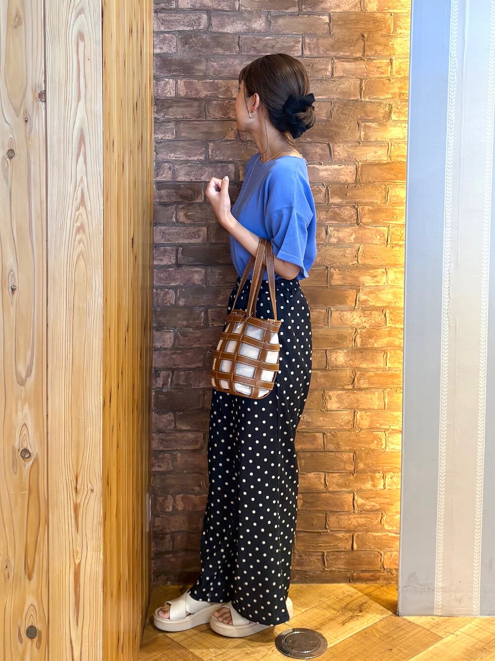 ブルー系のニット/セーター、ブラック系のその他パンツ、ベージュ系のサンダルを着用したレディースの夏コーディネートの2枚目の写真