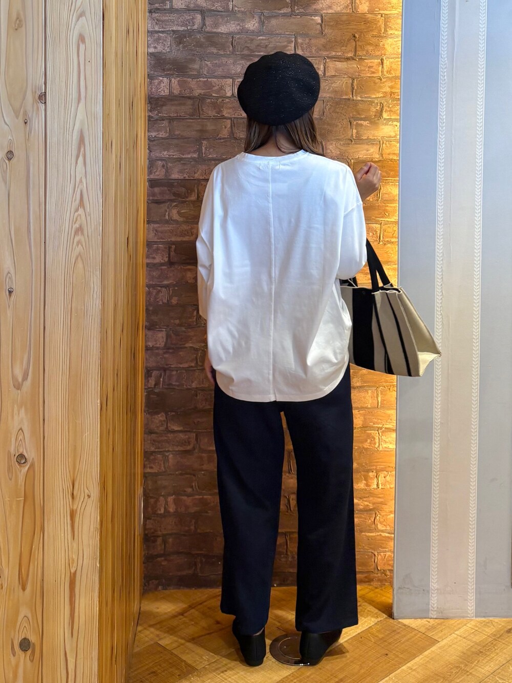 ホワイト系のTシャツ/カットソー、ブラック系のトートバッグ、ブラック系のその他シューズを着用したレディースの秋コーディネートの3枚目の写真