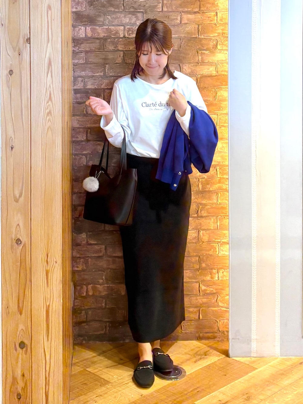 ブルー系のカーディガン/ボレロ、ホワイト系のTシャツ/カットソー、ブラック系のスカートを着用したレディースの秋コーディネートの4枚目の写真