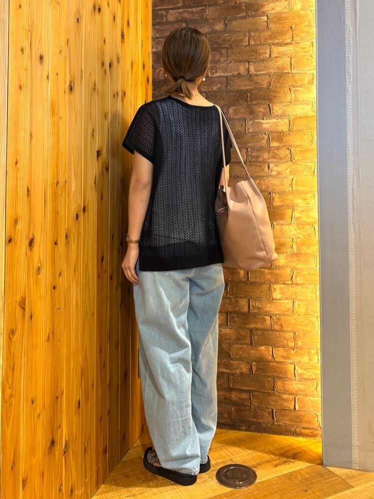 ブラック系のニット/セーター、ブルー系のデニムパンツ、シルバー系のサンダルを着用したレディースの夏コーディネートの3枚目の写真