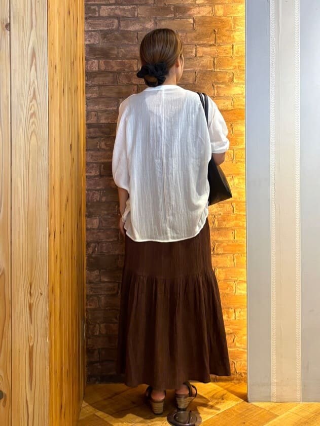 ホワイト系のシャツ/ブラウス、ブラウン系のワンピース、ブラック系のサンダルを着用したレディースの夏コーディネートの3枚目の写真