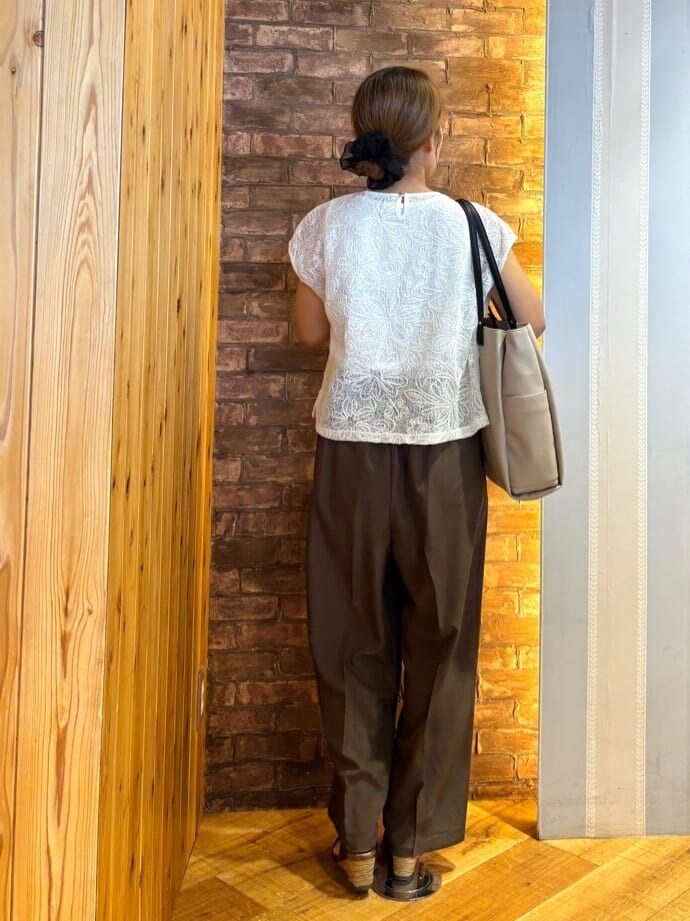 ホワイト系のその他トップス、ブラウン系のその他パンツ、ブラック系のサンダルを着用したレディースの夏コーディネートの3枚目の写真
