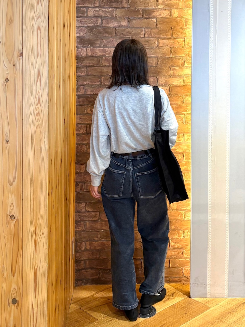 グレー系のTシャツ/カットソー、ブルー系のデニムパンツ、ブラック系のその他シューズを着用したレディースの秋コーディネートの3枚目の写真