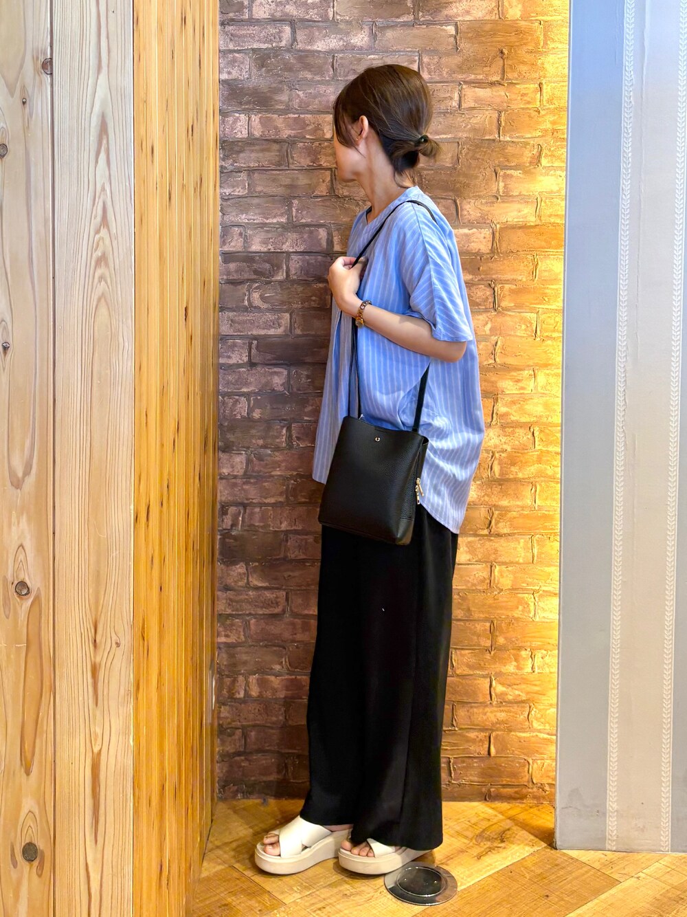 ブルー系のシャツ/ブラウス、ブラック系のその他パンツ、ベージュ系のサンダルを着用したレディースの夏コーディネートの2枚目の写真