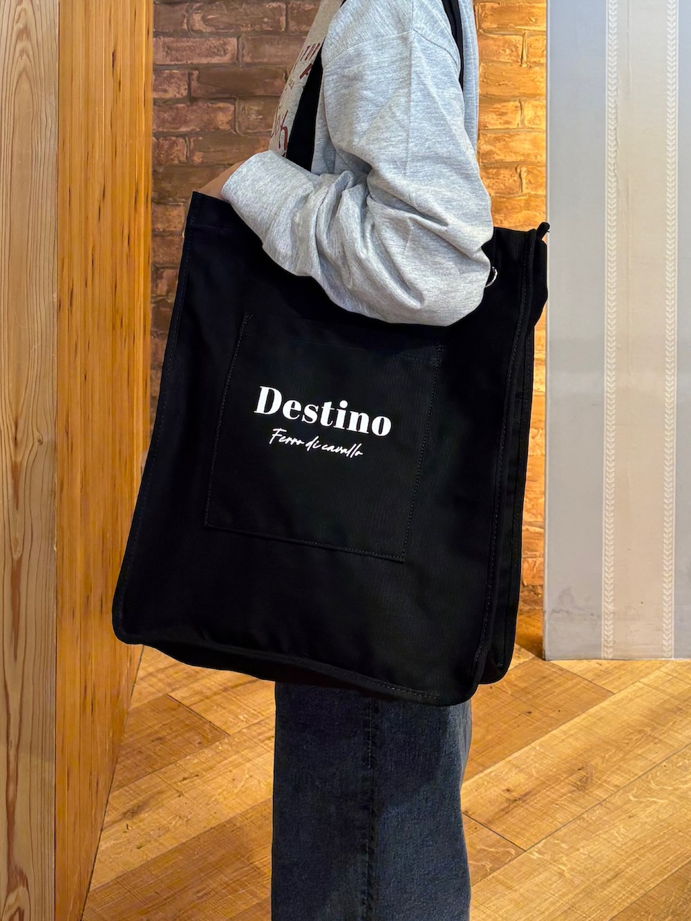 グレー系のTシャツ/カットソー、ブルー系のデニムパンツ、ブラック系のその他シューズを着用したレディースの秋コーディネートの5枚目の写真