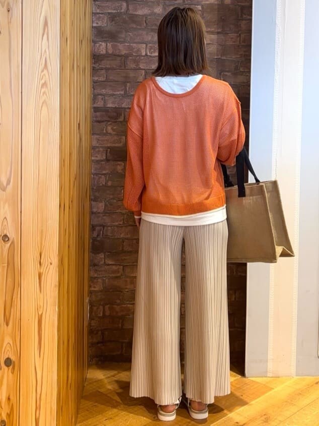 オレンジ系のその他トップス、ホワイト系のその他パンツ、ホワイト系のサンダルを着用したレディースの春コーディネートの3枚目の写真