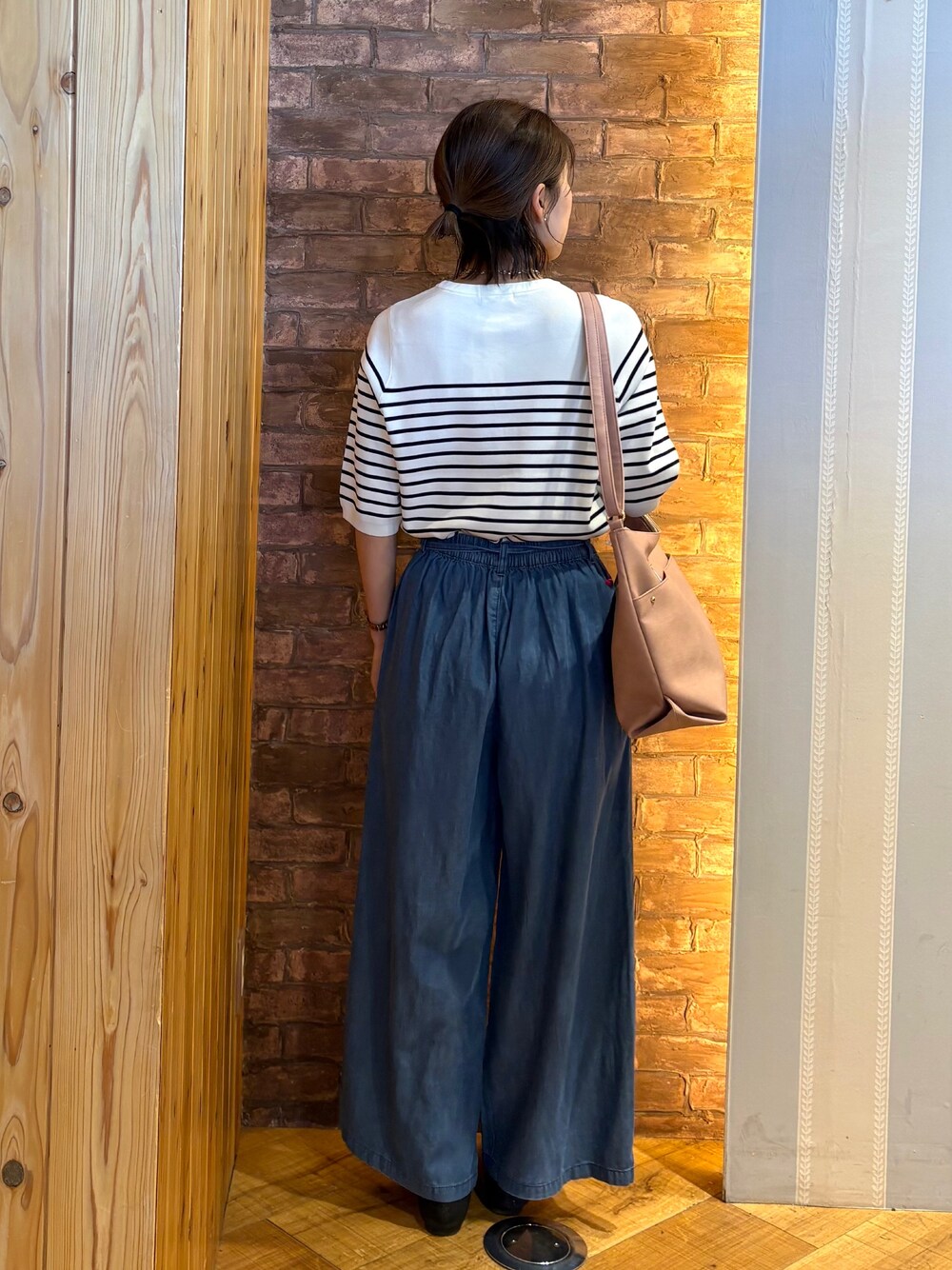 ベージュ系のショルダーバッグ、ホワイト系のニット/セーター、ブルー系のその他パンツを着用したレディースの春コーディネートの3枚目の写真