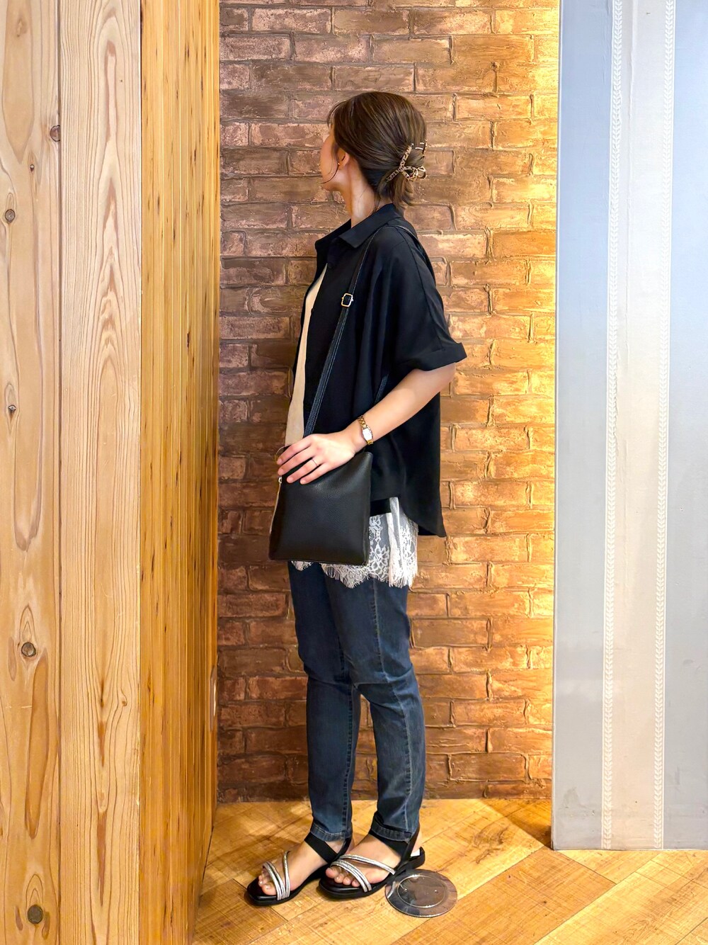 ブラック系のシャツ/ブラウス、ホワイト系のタンクトップ、ブルー系のデニムパンツを着用したレディースの夏コーディネートの3枚目の写真