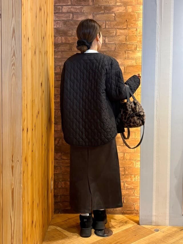 ブラック系のノーカラージャケット、ベージュ系のニット/セーター、グレー系のスカートを着用したレディースの冬コーディネートの3枚目の写真