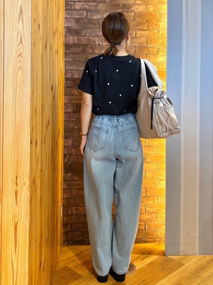 ブラック系のTシャツ/カットソー、ブルー系のデニムパンツ、ブラック系のサンダルを着用したレディースの春コーディネートの3枚目の写真