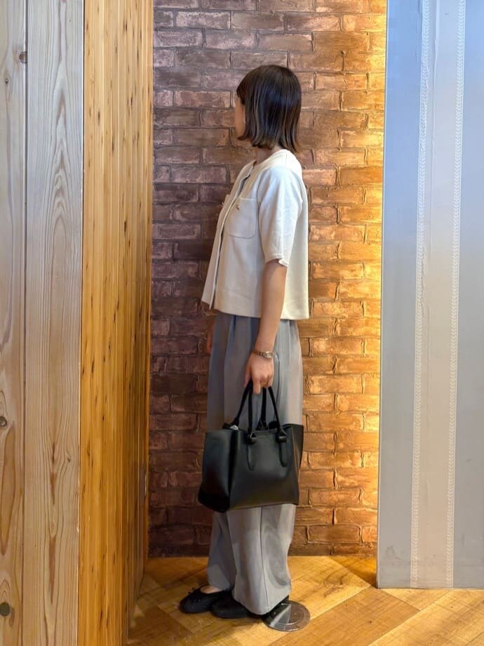 ブラック系のその他シューズ、グレー系のその他パンツ、ブラック系のトートバッグを着用したレディースの春コーディネートの2枚目の写真