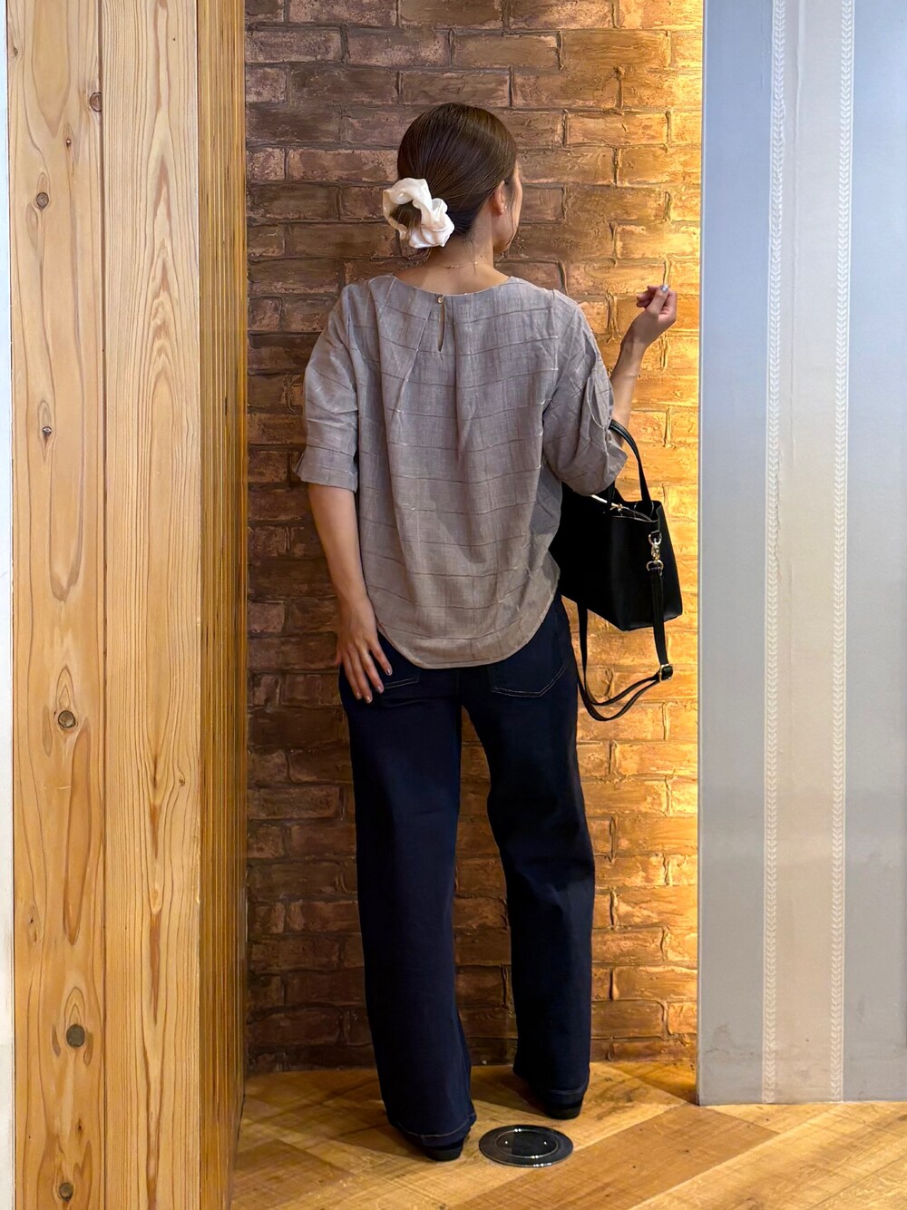 ベージュ系のシャツ/ブラウス、ブルー系のデニムパンツ、ブラック系のパンプスを着用したレディースの夏コーディネートの3枚目の写真