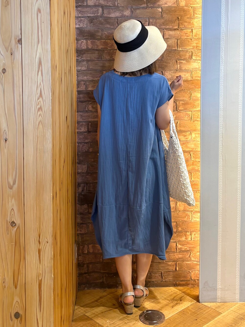 ブルー系のワンピース、シルバー系のサンダル、ホワイト系のトートバッグを着用したレディースの夏コーディネートの3枚目の写真