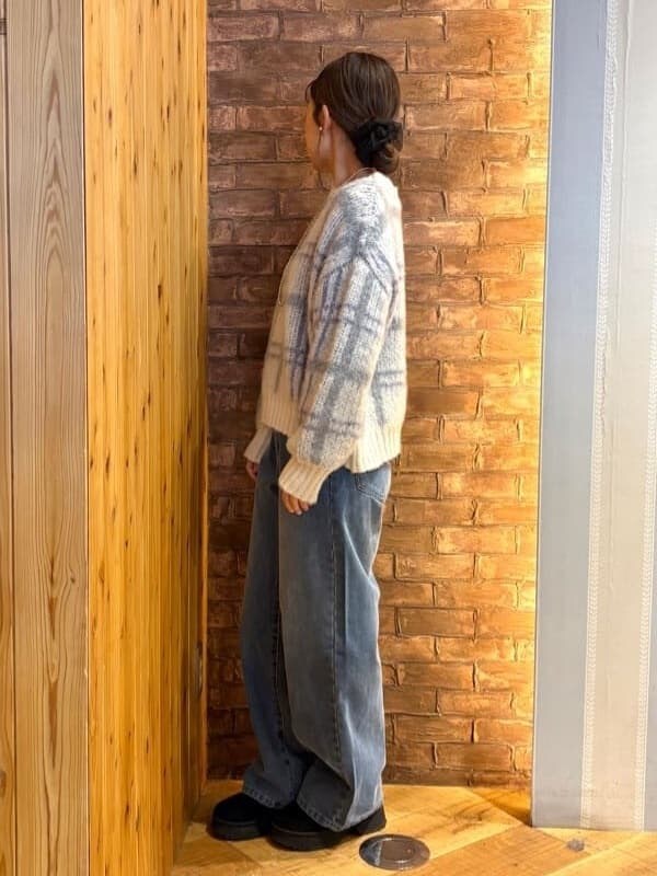 ホワイト系のニット/セーター、ブルー系のデニムパンツ、ブラック系のブーツを着用したレディースの冬コーディネートの2枚目の写真