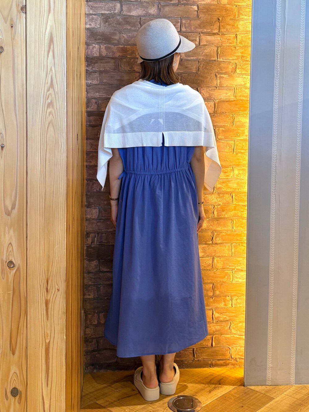 ホワイト系のカーディガン/ボレロ、ブルー系のワンピース、ベージュ系のサンダルを着用したレディースの夏コーディネートの3枚目の写真