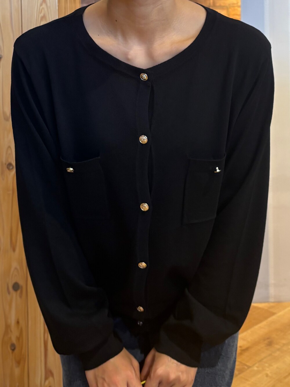 ブラック系のカーディガン/ボレロ、ブルー系のデニムパンツ、ブラック系のパンプスを着用したレディースの秋コーディネートの5枚目の写真