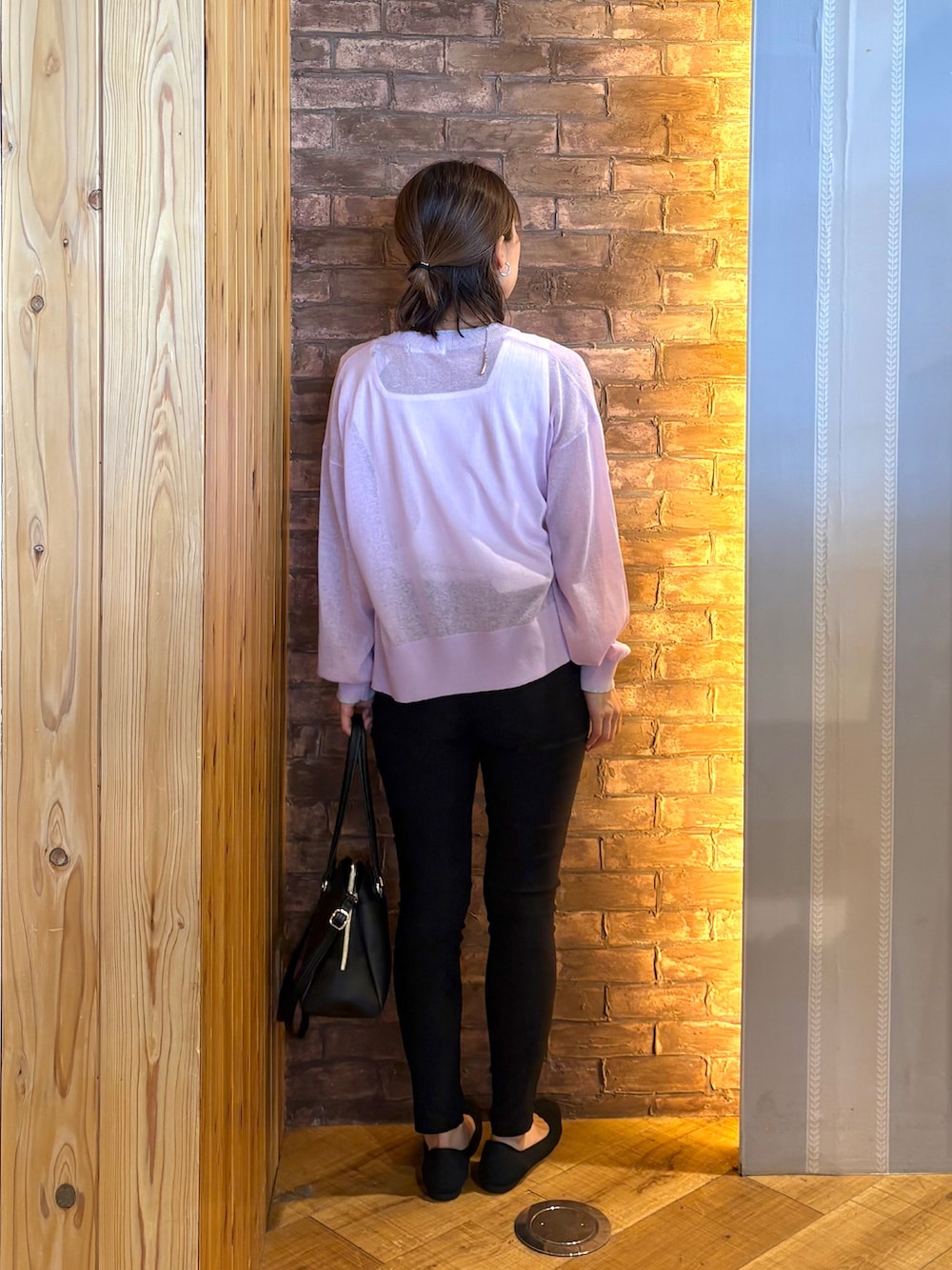 ブラック系のトートバッグ、ブラック系のパンプス、ホワイト系のタンクトップを着用したレディースの春コーディネートの3枚目の写真