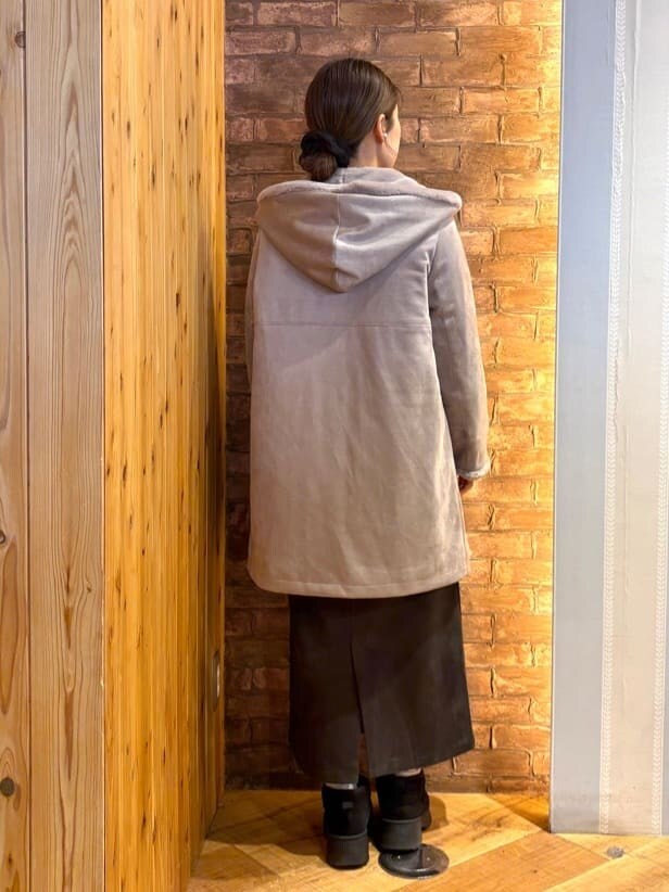 ブラウン系のその他アウター、ベージュ系のニット/セーター、グレー系のスカートを着用したレディースの冬コーディネートの3枚目の写真