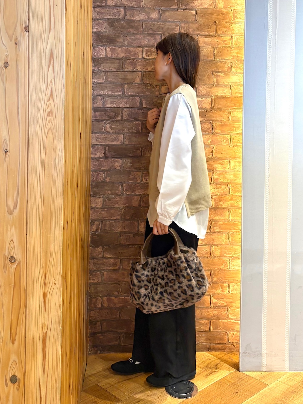 ブラック系のその他パンツ、ブラック系のその他シューズ、ブラウン系のトートバッグを着用したレディースの秋コーディネートの2枚目の写真