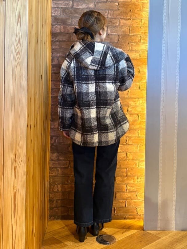 ブラック系のその他アウター、オレンジ系のTシャツ/カットソー、ブルー系のデニムパンツを着用したレディースの秋コーディネートの3枚目の写真
