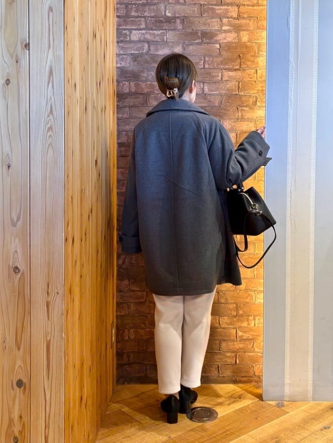 グレー系のチェスターコート、ピンク系のニット/セーター、ホワイト系のその他パンツを着用したレディースの冬コーディネートの3枚目の写真