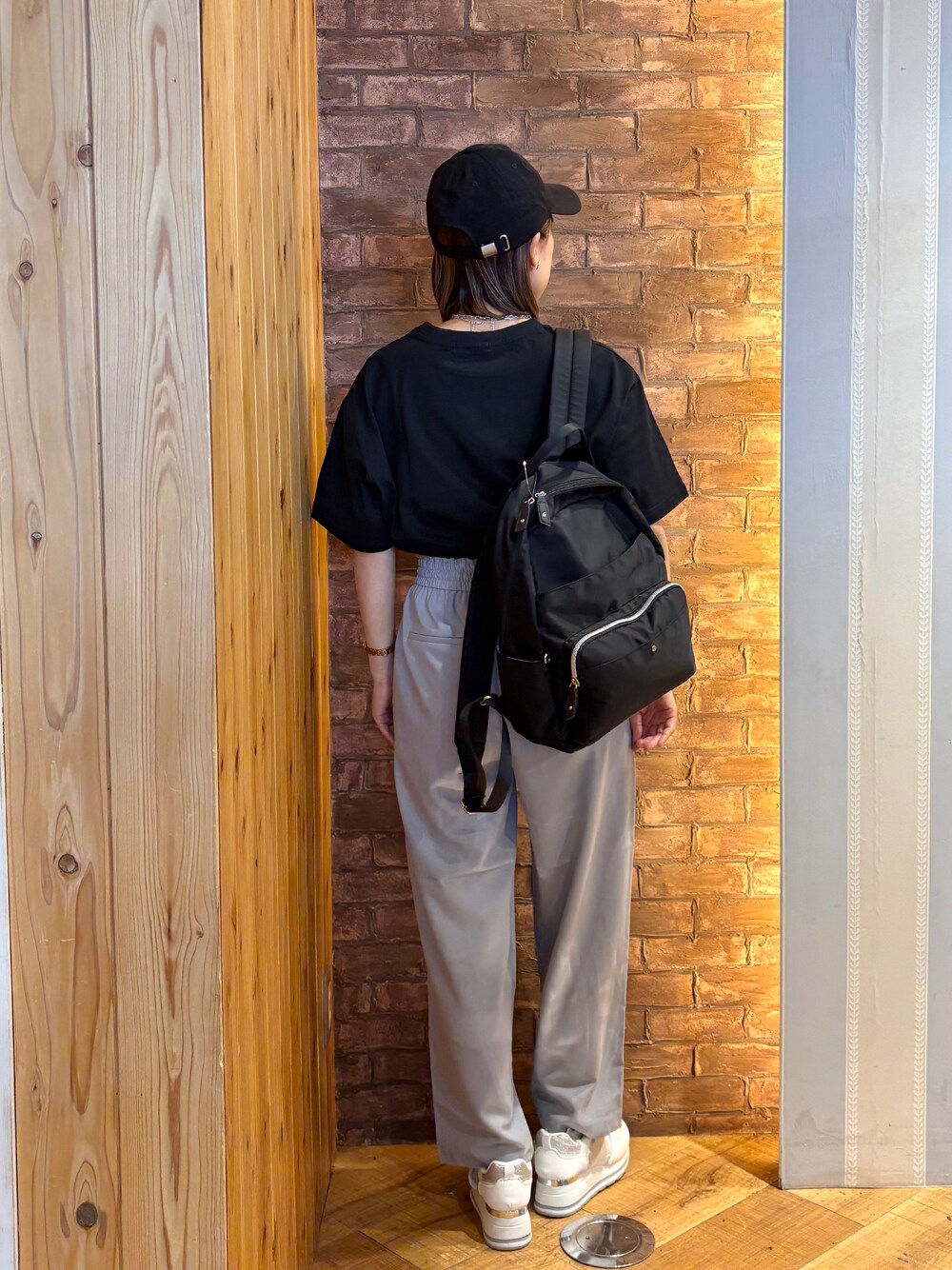 ブラック系のTシャツ/カットソー、ブラック系のバックパック/リュック、ホワイト系のスニーカーを着用したレディースの夏コーディネートの3枚目の写真