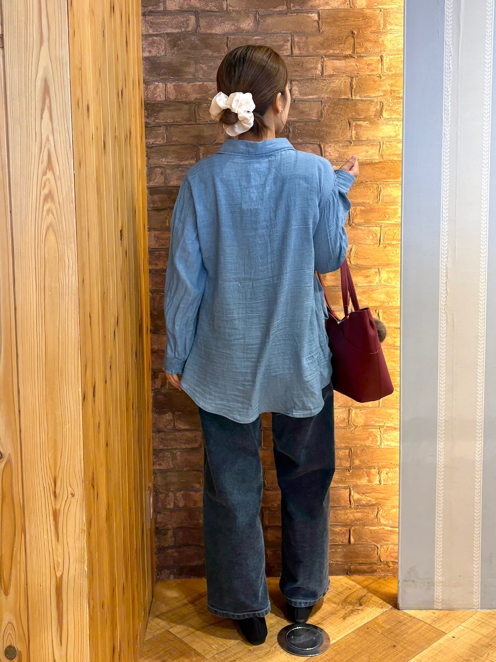 ブルー系のシャツ/ブラウス、ブルー系のデニムパンツ、ブラック系のその他シューズを着用したレディースの秋コーディネートの3枚目の写真
