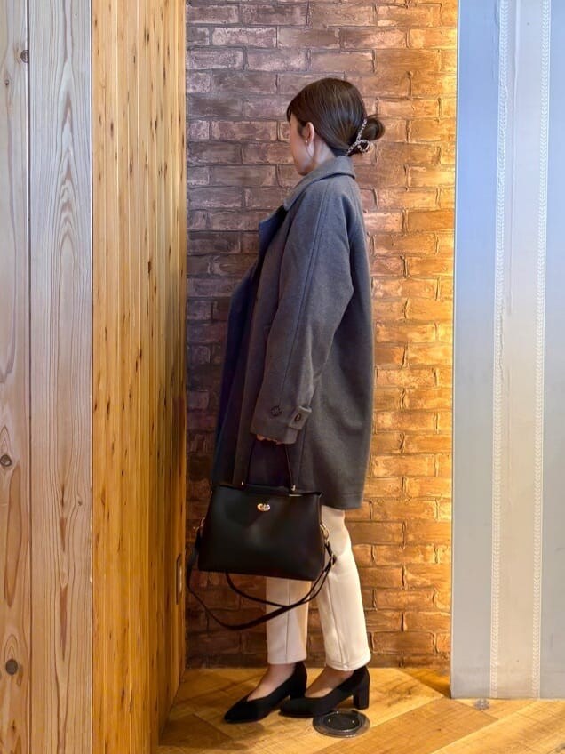 グレー系のチェスターコート、ピンク系のニット/セーター、ホワイト系のその他パンツを着用したレディースの冬コーディネートの2枚目の写真