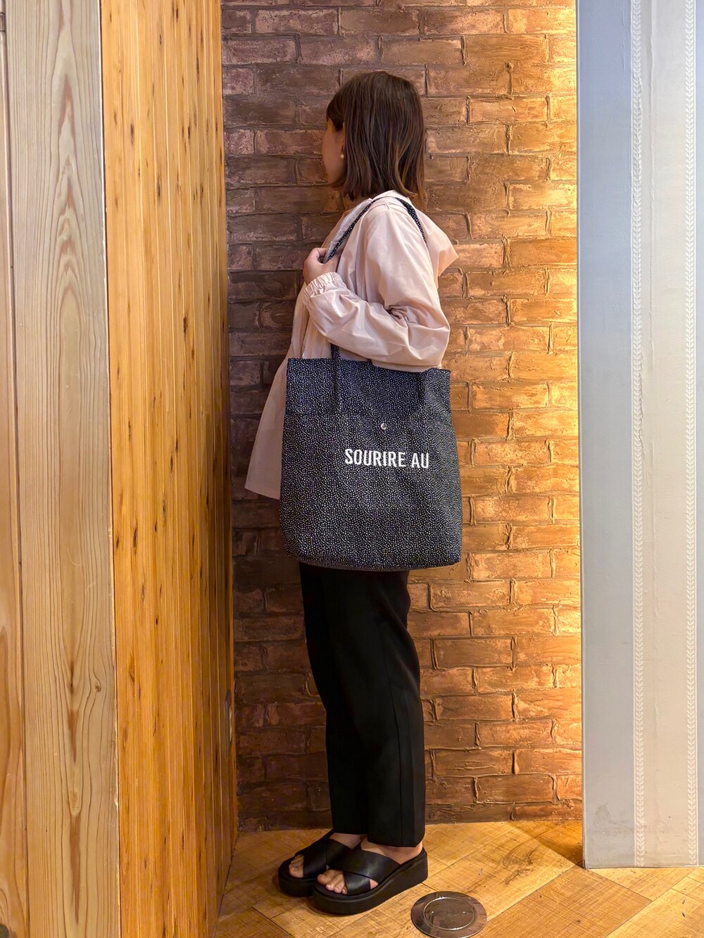 ホワイト系のTシャツ/カットソー、ブラック系のトートバッグ、ブラック系のその他パンツを着用したレディースの春コーディネートの2枚目の写真