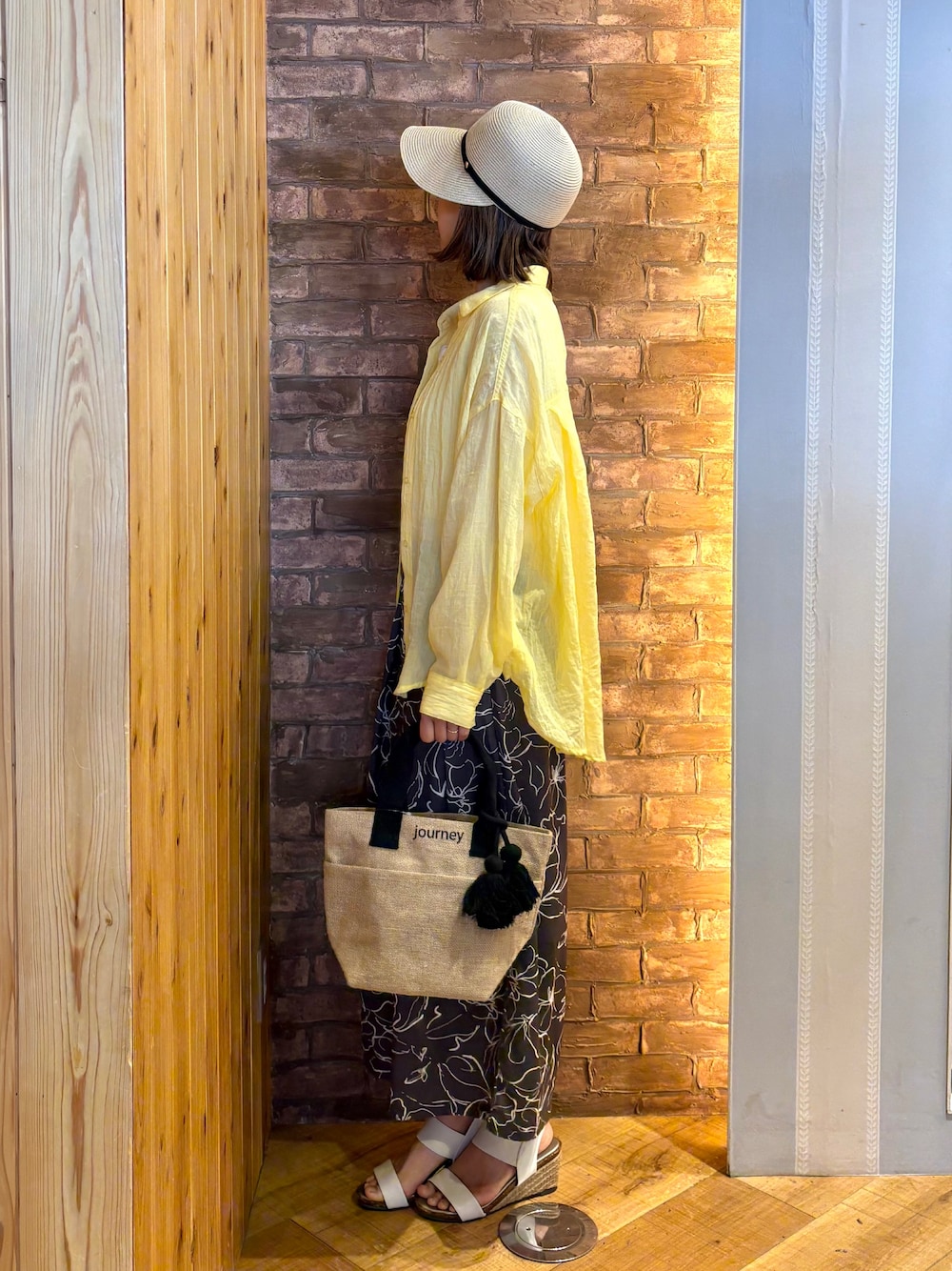 ブラック系のトートバッグ、ブラウン系のその他パンツ、イエロー系のシャツ/ブラウスを着用したレディースの春コーディネートの2枚目の写真